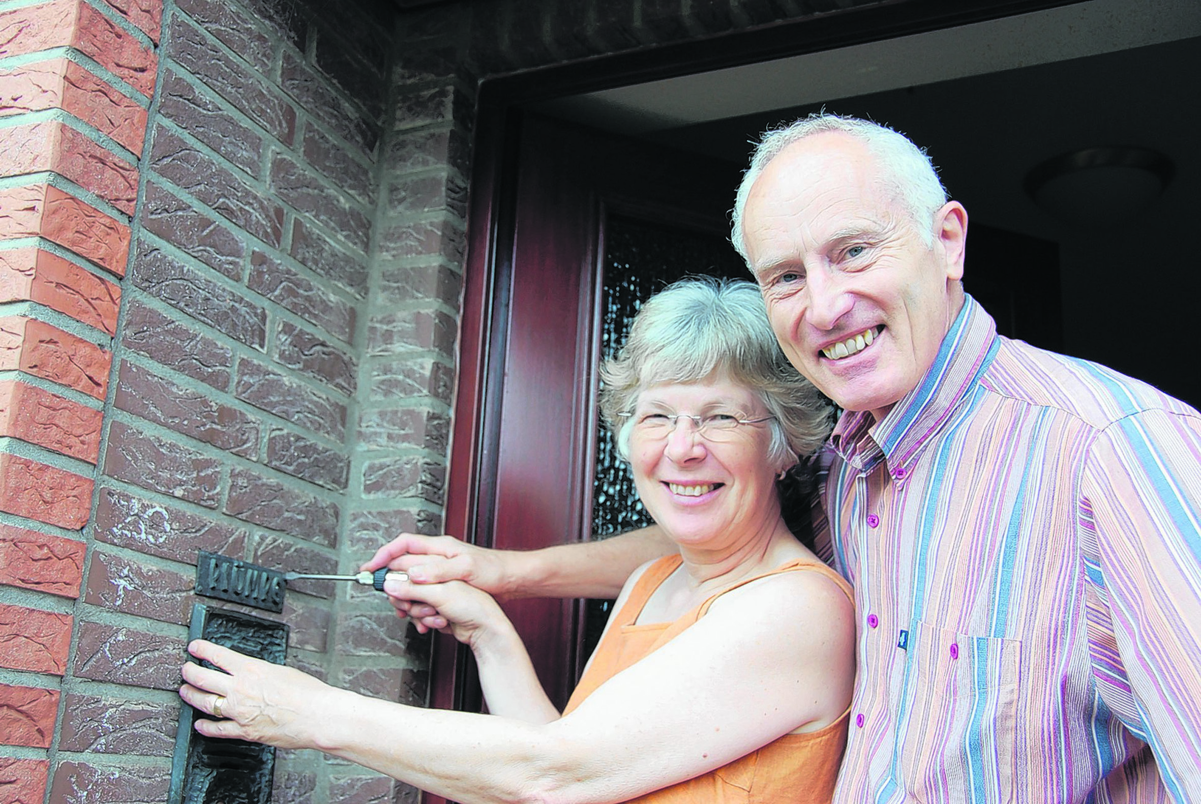 Angelika und Walter Plümpe schrauben gemeinsam am Türschild. Über 34 Jahre hat das Ehepaar in Xanten gelebt. Jetzt zieht es die beiden vom Rhein an die Spree.
