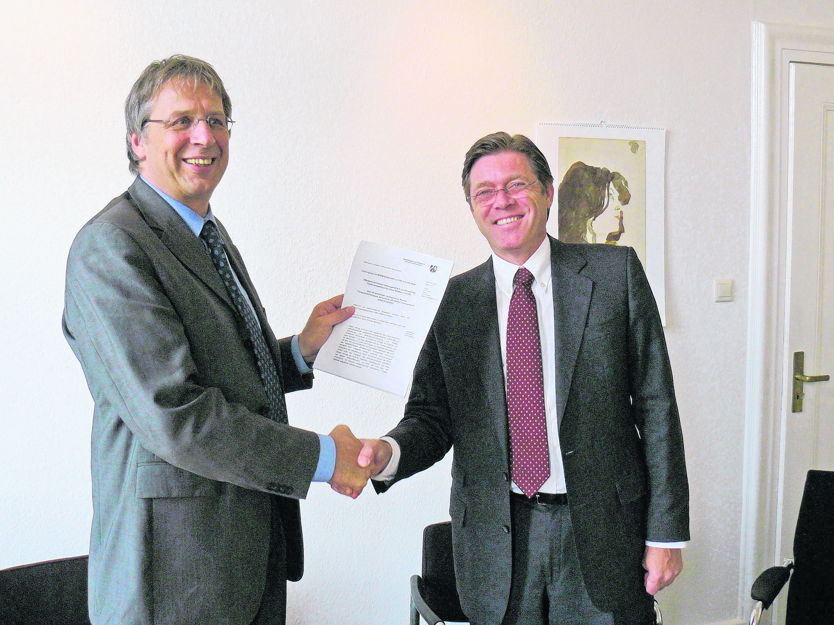 Freude über die erfolgreich abgeschlossenen Vertragsverhandlungen bei Regierungsvizepräsident Roland Schlapka und DELA-Geschäftsführer Christian Bonmann.