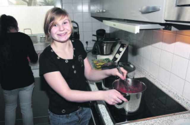 Eva-Maria stellte auch am Herd ihr Können unter Beweis und rührte fleißig an der Tomatensoße, für die zuvor das frische Basilikum gehackt worden war. Foto: Gerd Kaemper
