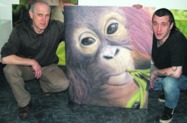 Dieses Kunstwerk ähnelt dem Patenkind der Gardings dermaßen, dass Martina Garding sich sofort in das Bild aus der Airbrush-Pistole von Olaf Schubert (rechts) verliebte. Rainer Garding (links) hatte dafür die Aufgabe der Abwicklung der Spende. Foto: Pasch