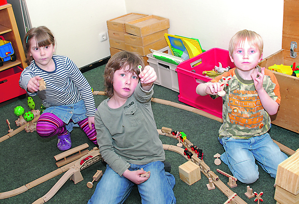 Julia (6), Louis (6) und Philip (6) der ev. Kindertageseinrichtung St. Georg freuen sich über schadstofffreies Holzspielzeug in ihrem Kindergarten. Foto: Kamphorst