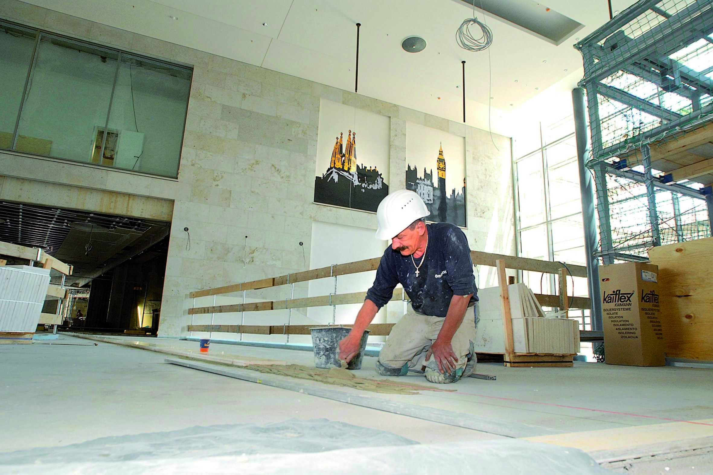 Wahrzeichen aus London und Barcelona schmücken schon die Wände der neuen Thier Galerie, in der gerade die Bodenplatten verlegt werden. Jetzt beschert das Shopping-Center dem Handwerk Jobs, bald dem Handel. Fotos: Schmitz