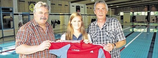 Lena Busch mit Gratulanten von der Stadt Unna: Paul Raupbach (Sportausschussvorsitzender/re.) und Uli Seliger (Leiter Sport-Service-Unna/li.) überreichen ein Geschenk.