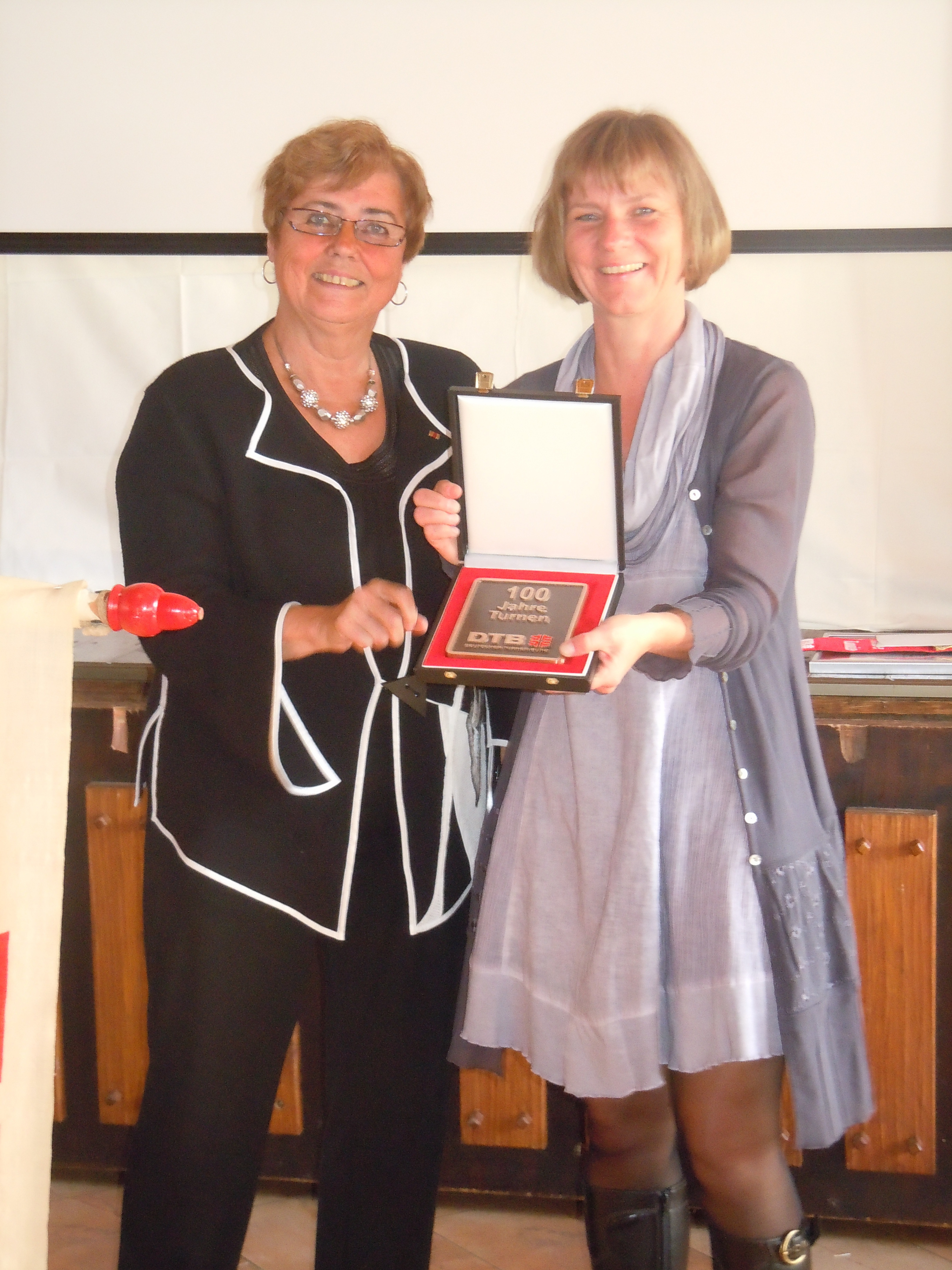 Gerda Ottner überreichte der 1. Vorsitzenden des Turnerbundes, Bärbel Wittnebel (r.), das Schild des Deutschen Turnerbundes.
