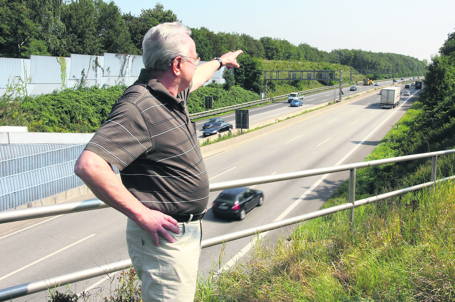 Wilhelm Bialy, der Sprecher der Bürgerinitiative betroffener Anwohner am Birkenkamp, zeigt hier den Lärmschutzwall, der aus Sicht der Anwohner um 2,50 m höher gebaut werden müsste, um die Menschen vor dem Lärm zu schützen. Foto: Gerd Kaemper