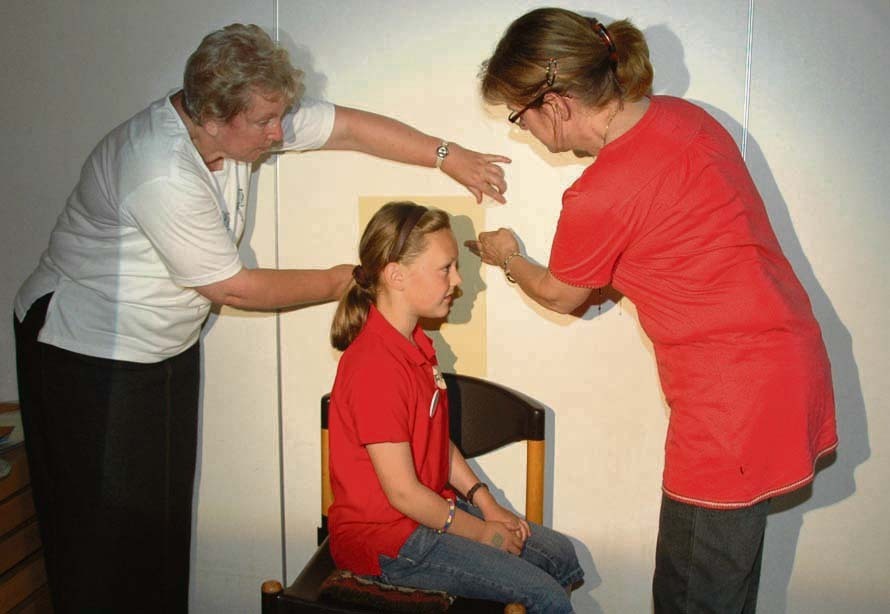 Das Profil dieses Mädchens malen die beiden KFD-Frauen ab. Hinterher können es die Kinder selbst ausschneiden. Fotos: Jörg Terbrüggen