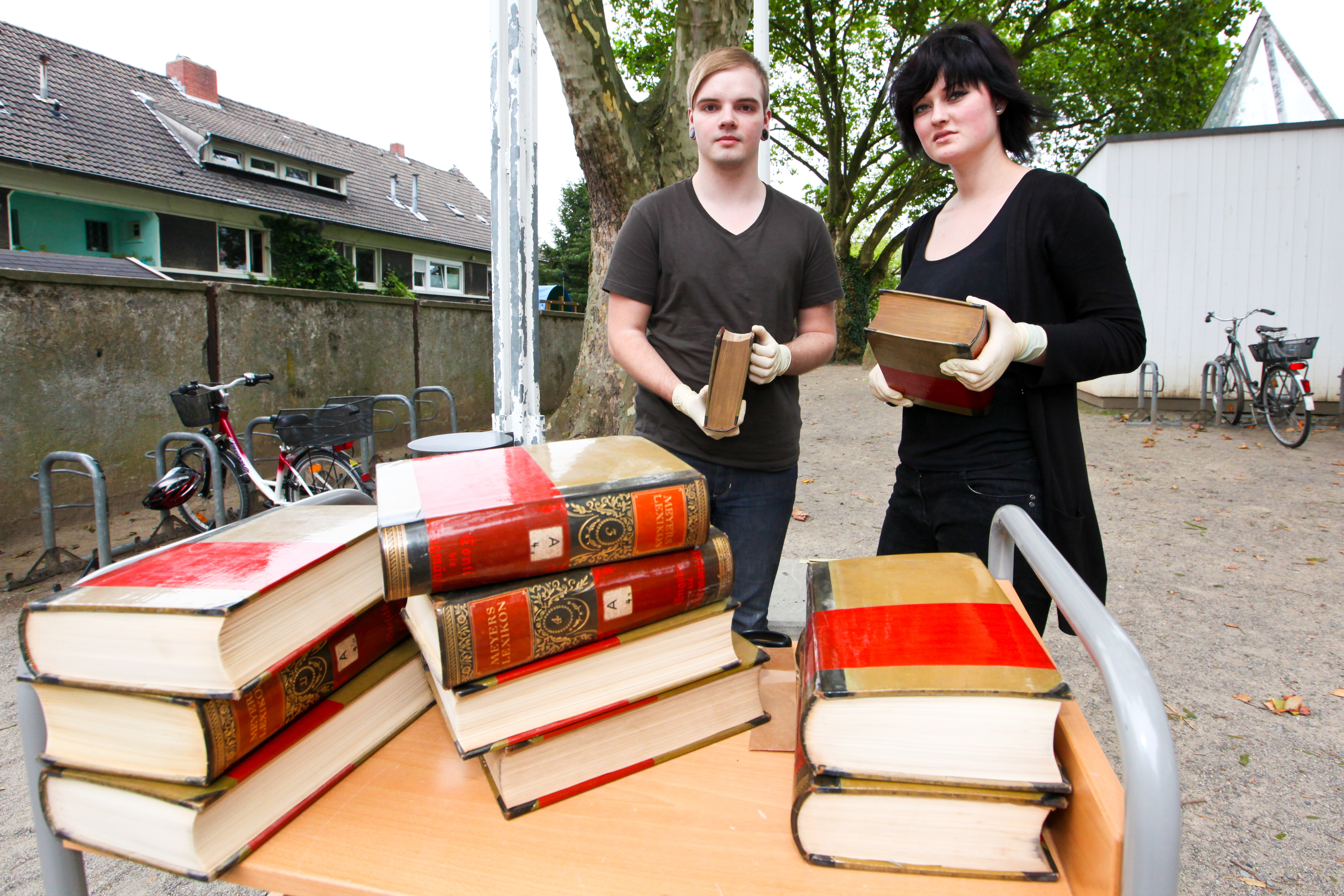 Alexander Hippler (23) u. Sarah Zielinski (20) beim Reinigen der Bücher