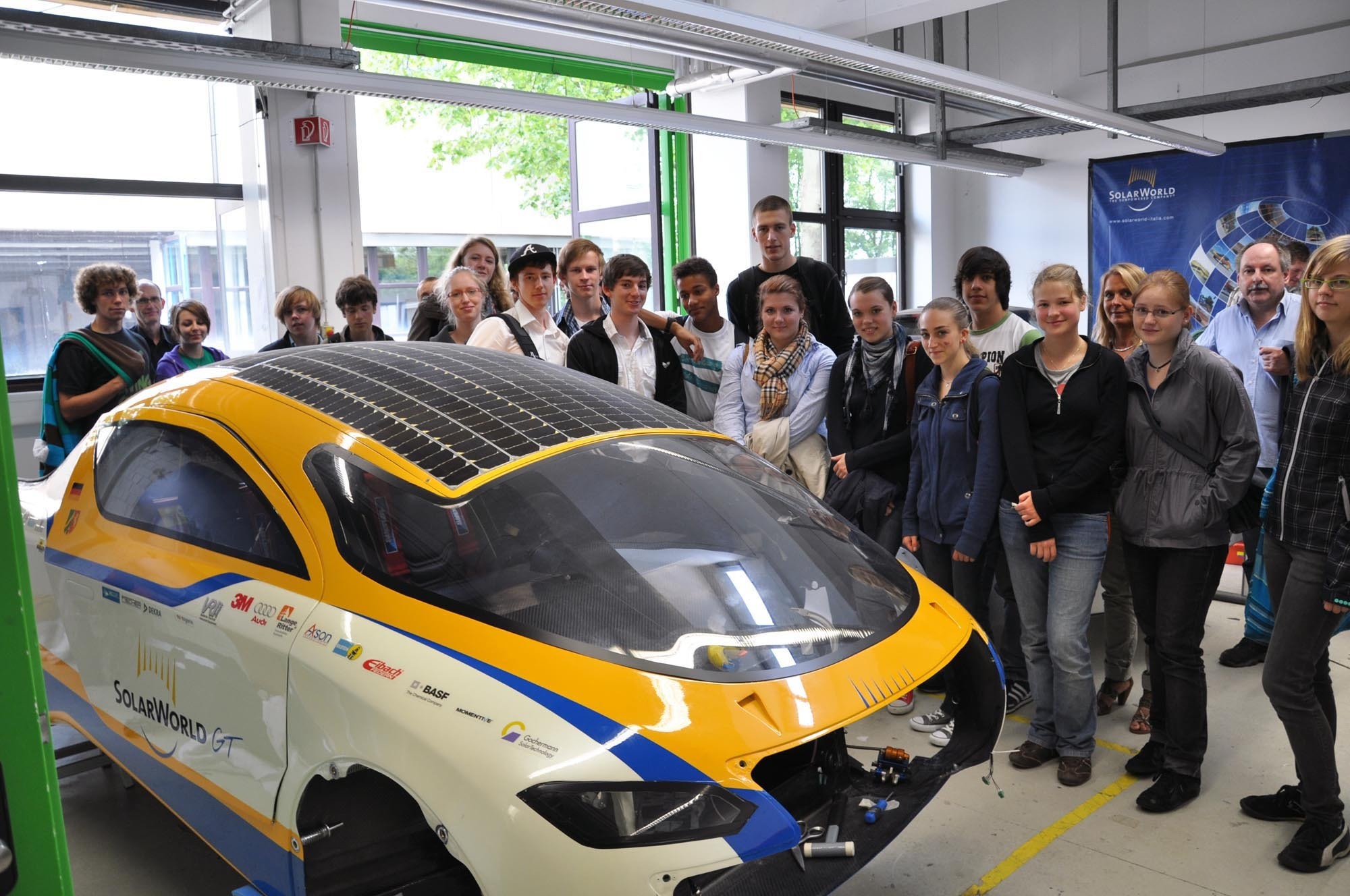 Die SommerCamper blicken über das neue Solarcar „SolarWorldGT“ der Hochschule Bochum.