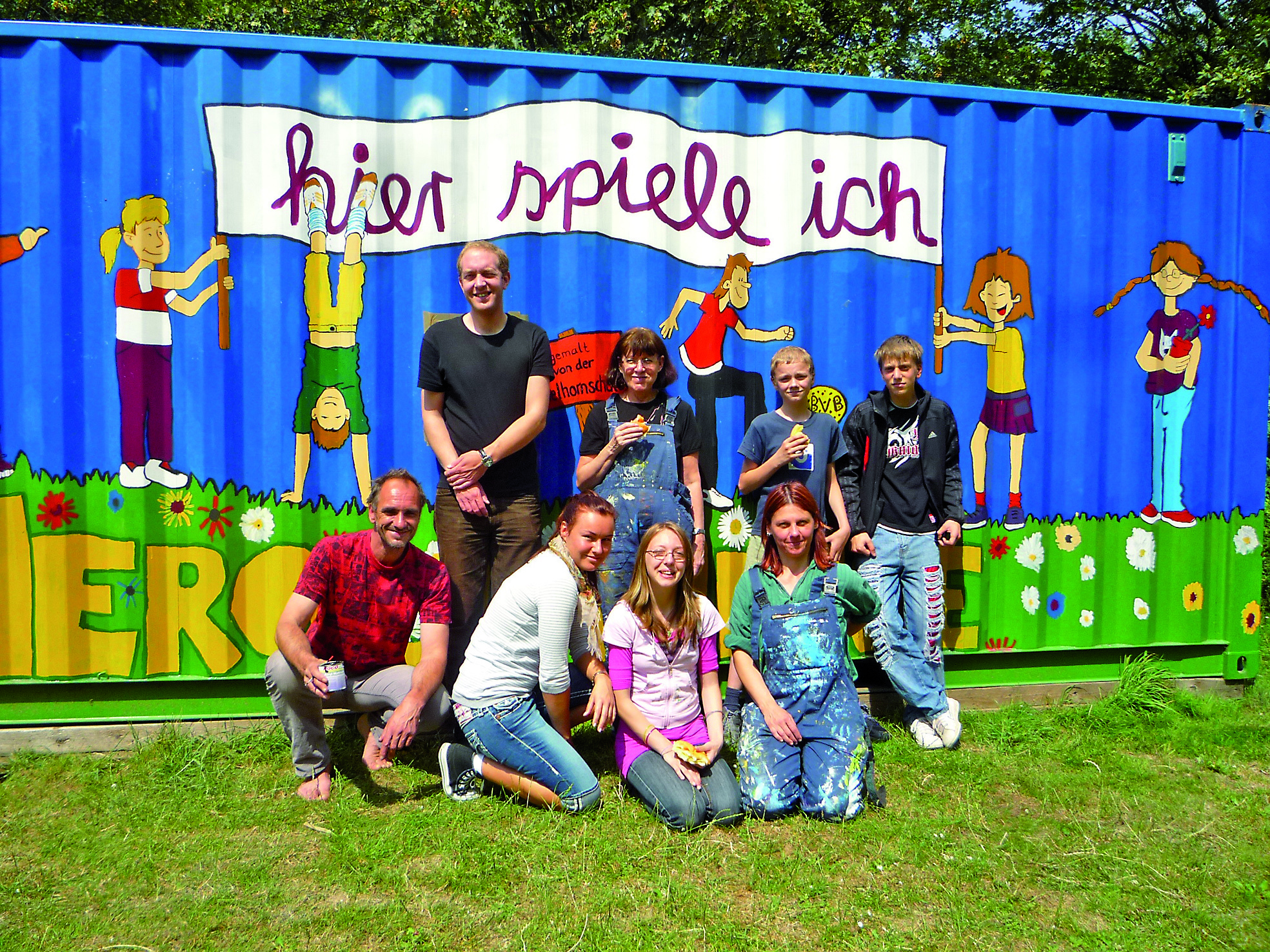Stolz präsentieren die Kinder den bunt bemalten Container.