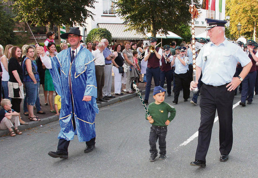 Beim Umzug vom Marktplatz zum Kolpinghaus in Elten marschierte Pierre Spiertz zwischen Horst Derksen vom Musikverein und Hans Kersjes vom Tambourcorps mit. Foto: Ralf Beyer