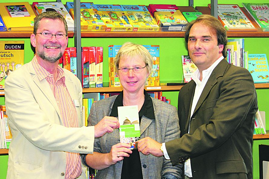 Diese Flyer zu „Literatur im Carré“ sind außer in der Stadtbibliothek an vielen Stellen der Stadt zu bekommen, hier präsentiert von (v.l.) Bernd Jeucken, Petra Kamburg (VHS) und Jörg Waldrich, Center-Manager vom Reschop Carré. Foto: Römer