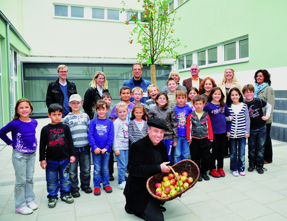 Schüler und Lehrer pflanzten einen Apfelbaum in den Innenhof ihrer „neuen“ Schule.