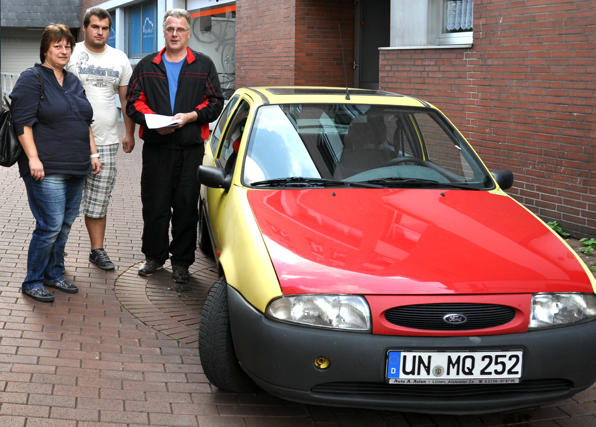 Gabriele, Steffen und Uwe Krautwald mit ihrem Auto: Der Ford Fiesta ist gelb und hat nur eine rote Motorhaube. Aber das Nummernschild ist gleich. Foto: Backmann-Kaub