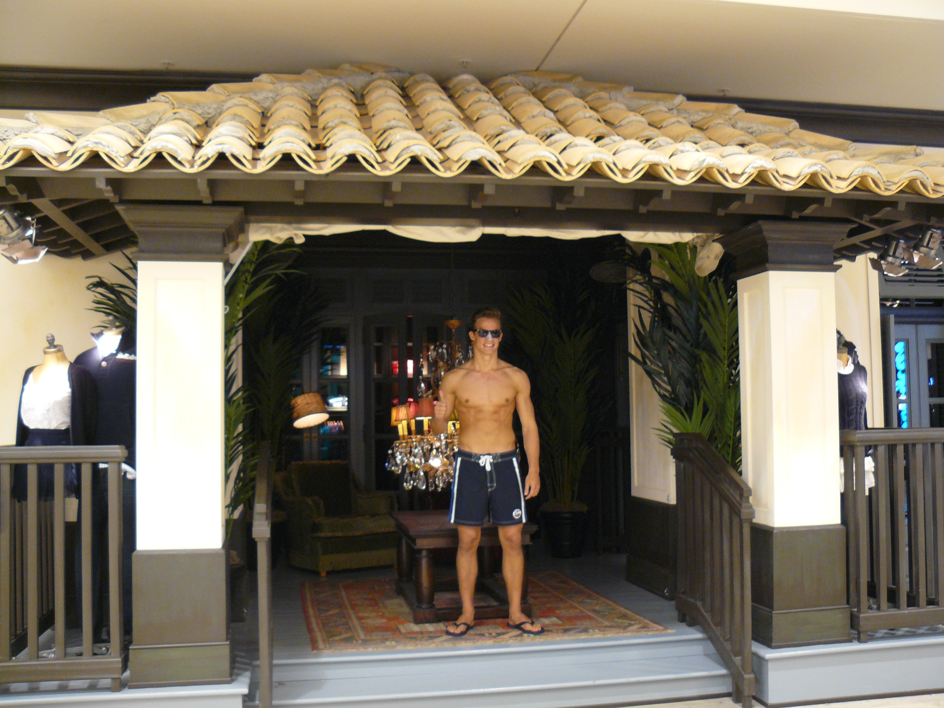 Sonnenbrille, Flip Flops und knackiger Body - so steht er nicht am Strand, sondern vor dem Modeladen.