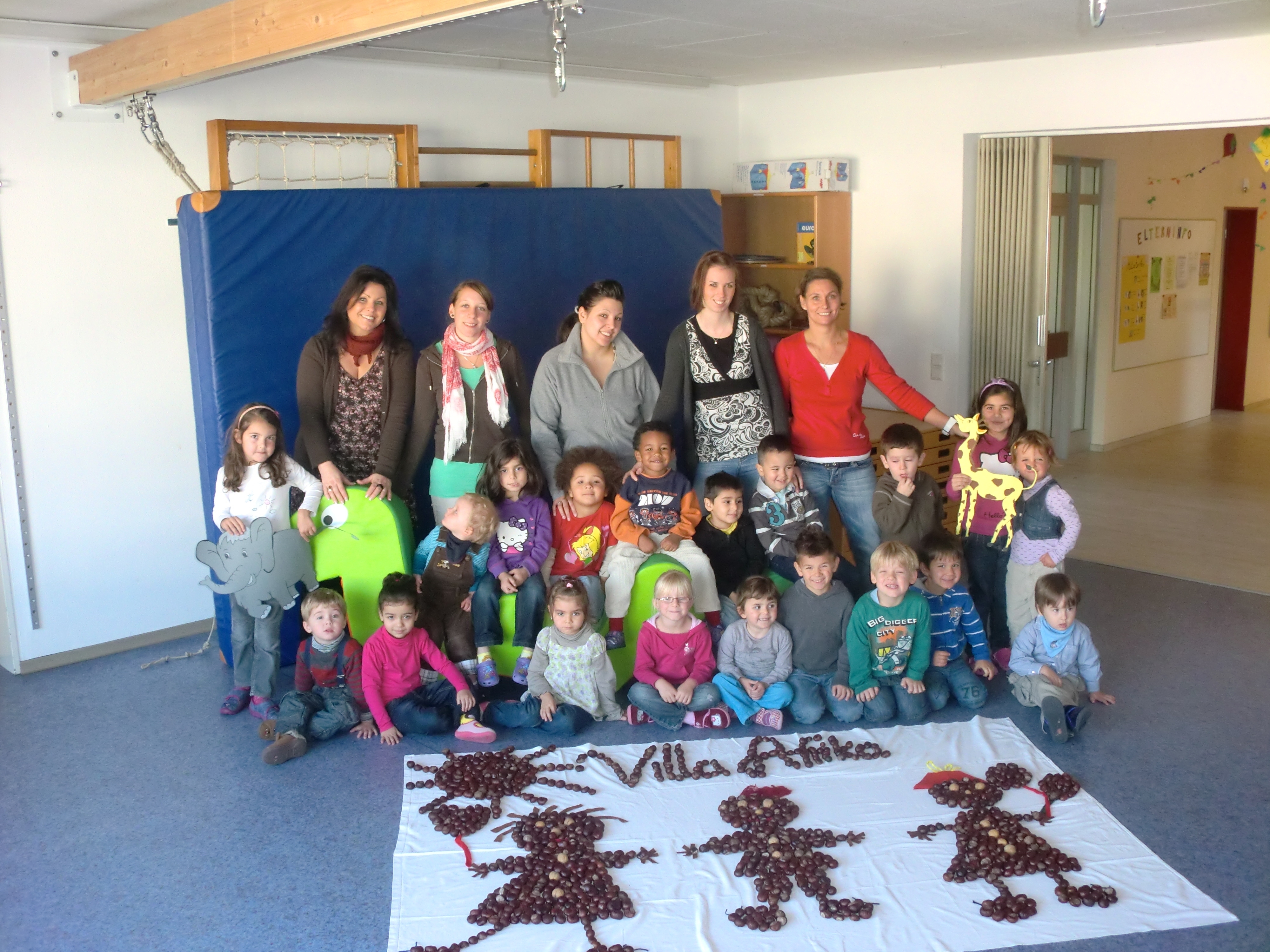 Die Kinder der "Villa Afrika" präsentieren stolz das Logo ihres Kindergartens, gelegt aus Kastanien.