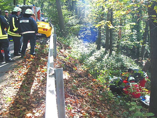 Obwohl er über die Leitplanke flog und drei Meter tiefer in der Böschung landete (rechts bei der Erstversorgung am Unfallort), wurde der Radfahrer nur leicht verletzt. Foto: Feuerwehr Hattingen