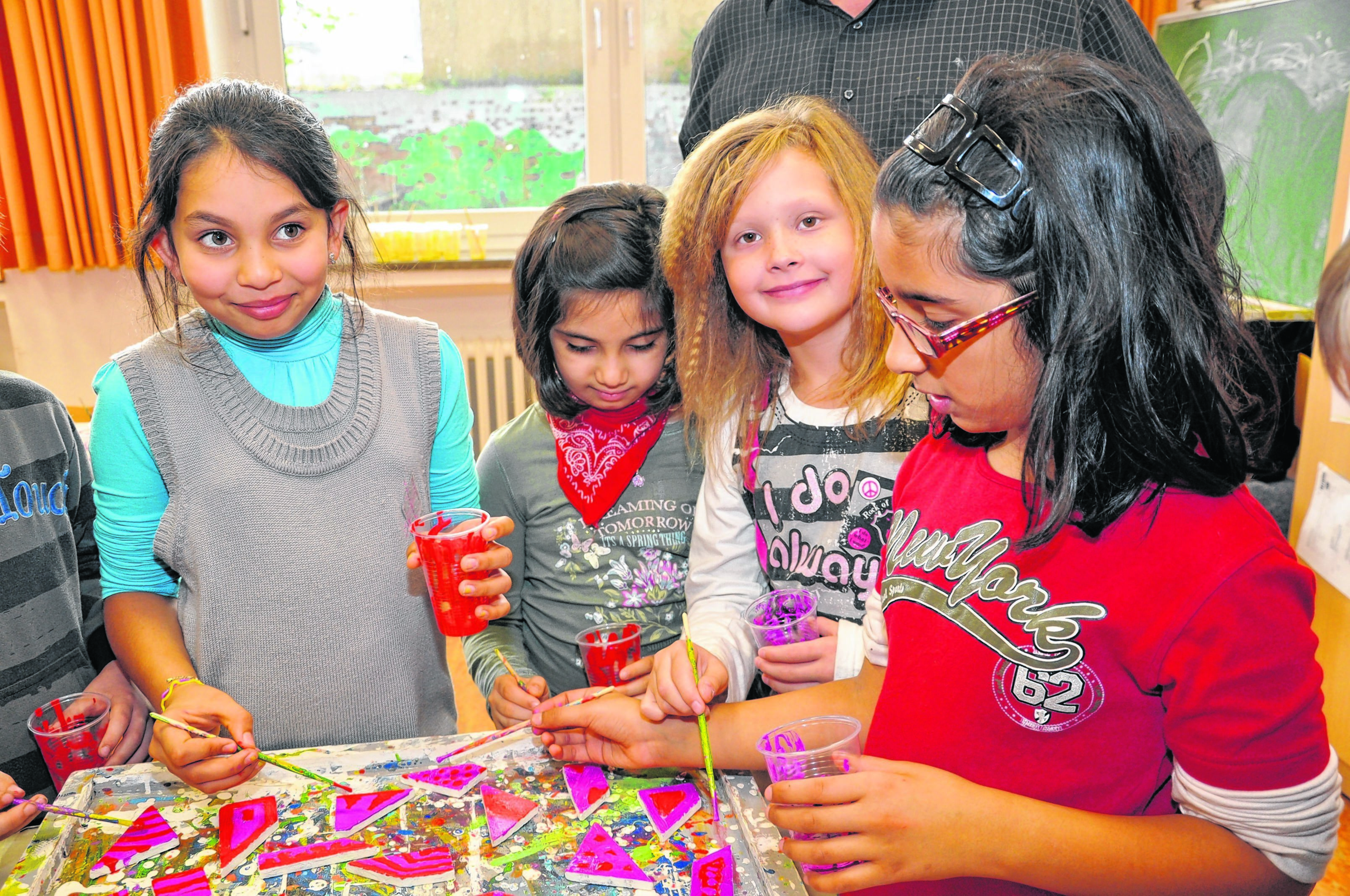 Mallika, Angelina, Hema und Sanita (v.re.) aus der 3b haben auch jeweils zwei Plättchen bemalt - natürlich in den Lieblingsfarben von Mädchen: in rot und pink.