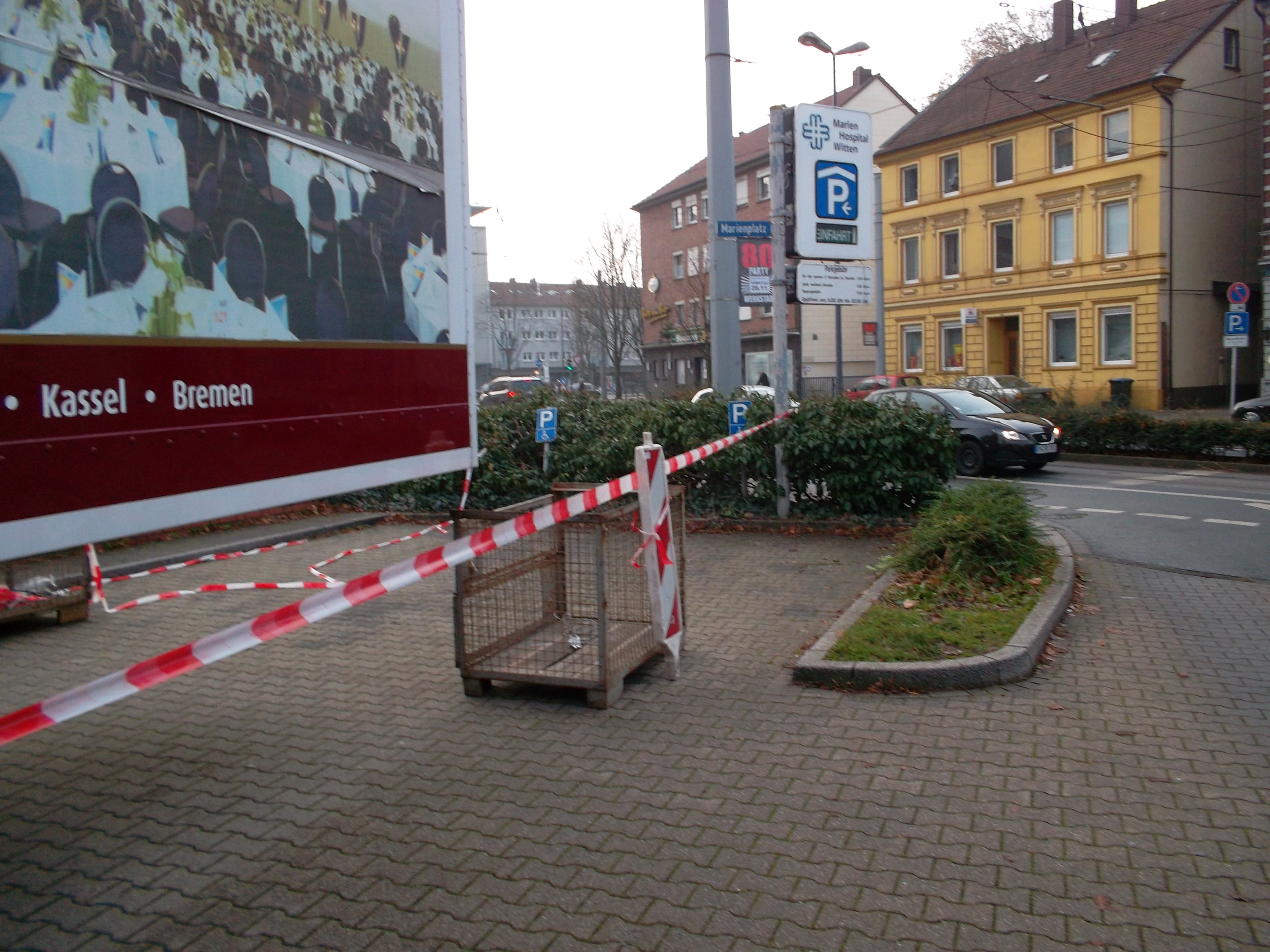 dieser Lkw-Anhänger und das Flatterband versperrten noch am 24.11.2011 um 09,15 Uhr die Zufahrt zum Behindertenparkplatz!