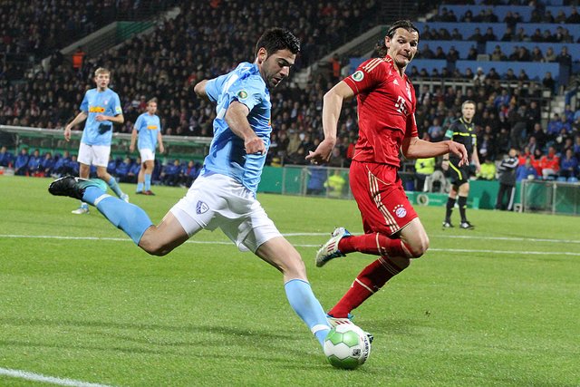 Die hervorragende Kombination,  die bei den VfL-Fans unter den 29.299 Zuschauern Hoffnungen auf die Sensation weckte: Nach einem feinen Pass von Takashi Inui ließ sich Mirkan Aydin (l.) von Bayern-Verteidiger Daniel van Buyten in der 22. Minute nicht bremsen, flankte flach und präzise in den Rücken der Gäste-Abwehr. Giovanni  Federico verwandelte aus kurzer Distanz zur Halbzeitführung. Nationaltorhüter Manuel Neuer war machtlos. | Foto: Molatta
