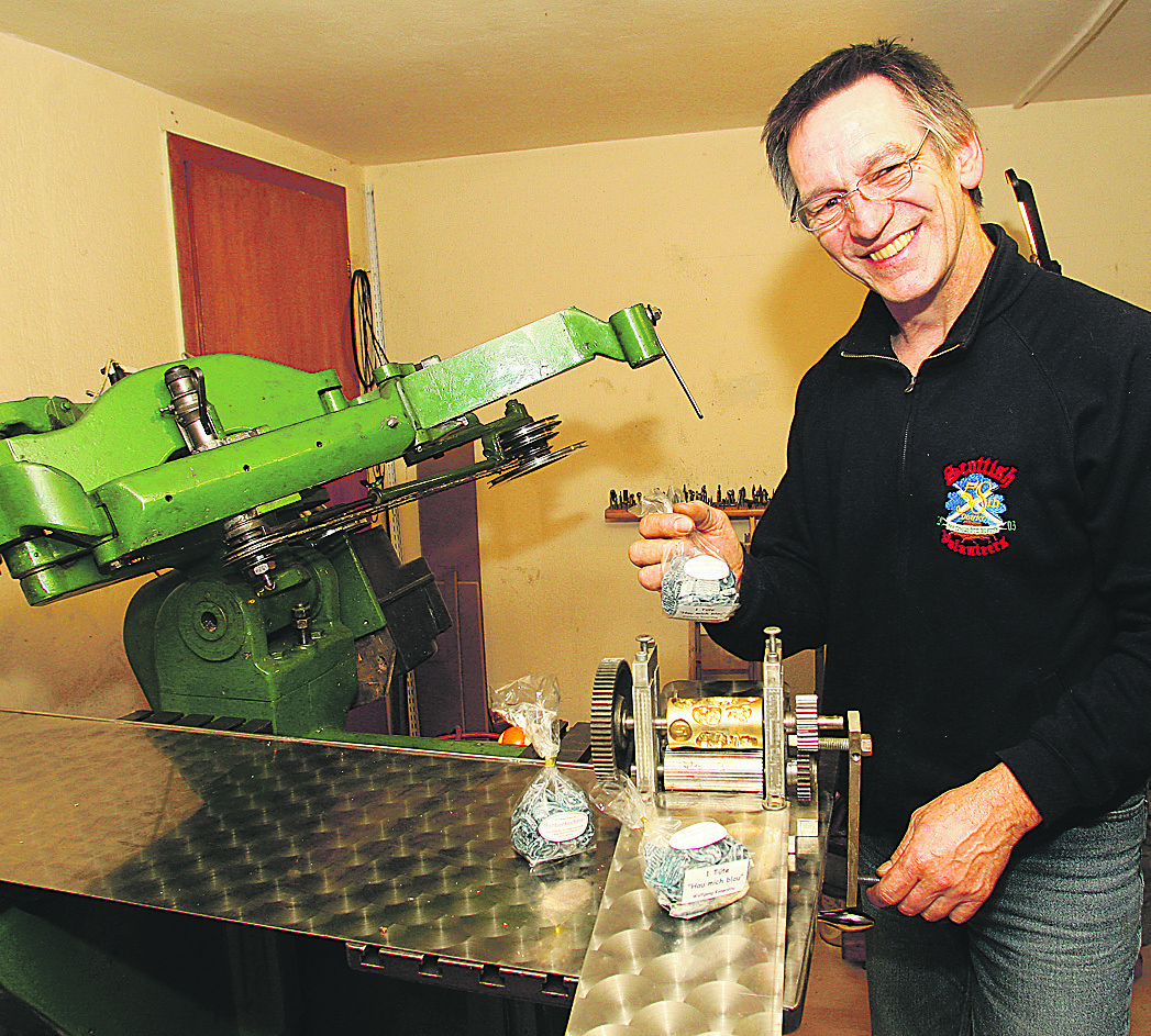 Wolfgang Konerding an seiner selbstgebauten Bonbonmaschine. Hier entstanden die ersten Prototypen für die Tüte „Hau mich blau“. Foto: Sander