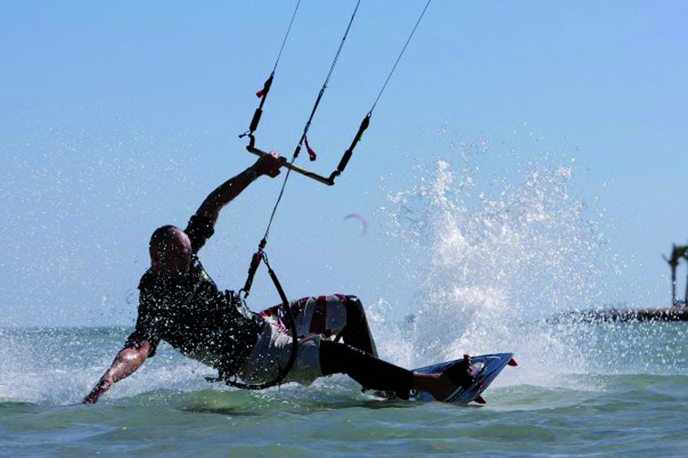 Mark Dürschlag beim Kitesurfen: Er steht auf einem Board und ist über ein Trapez mit einem Lenkdrachen verbunden, der ihn übers Wasser zieht. Die Leine ist 27 (!) Meter lang. Foto: Mark Dürschlag