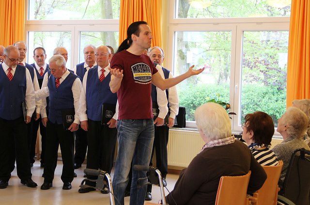 Herr Becker vom Heim begrüßt die Besucher und den Chor.