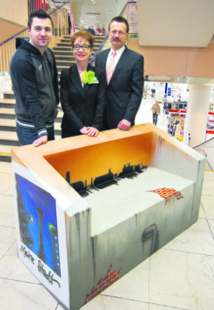 Graffiti-Künstler Marten Dalimot hat die Sitzbank gestaltet, die Johanna Groeneweg-de Kroon, Filialgeschäftsführerin der Galeria Kaufhof, und Thomas Diederichs, Vorstandsmitglied der Volksbank Rhein-Ruhr, zu Gunsten des Kinderheims St. Josef gemeinsam versteigern wollen. Die Partner hoffen, dass sich möglichst viele Mitbürger an der Benefizversteigerung beteiligen. Foto: Kirchner