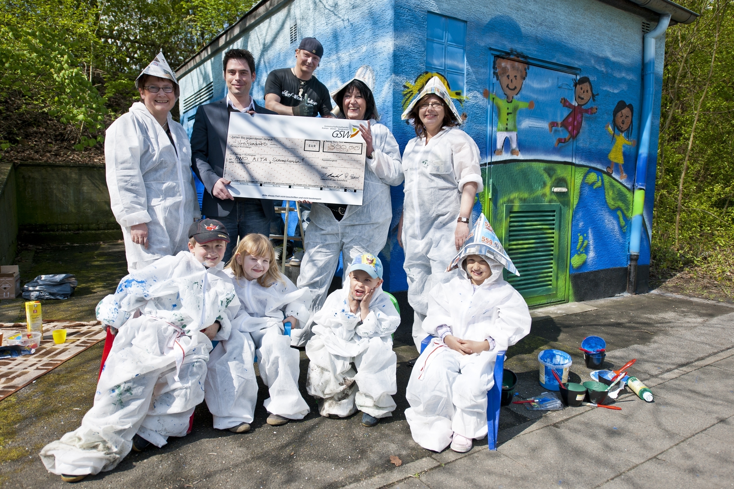 GSW-Pressesprecher Timm Jonas mit Agya, Marvin, Jannik und Philina, Kindergartenleiterin Frau Schütte mit zwei Kolleginnen und dem Künstler Ted Bartnik. Foto: privat