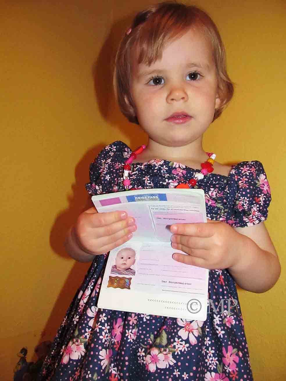 Stolz präsentiert das kleine Mädchen hier ihren ersten Reisepass.