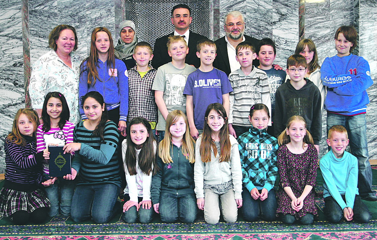 Einen interessanten Vormittag erlebten die Schüler der Klasse 4a der Heggerfeldschule in der Moschee an der Martin-Luther-Straße. Imam Ibrahim Akkurt und Sengül Özkan (beide hinten in der Mitte) machten sie mit der für die meisten Kinder fremden Umgebung vertraut und beantworteten viele Fragen rund um Islam, Koran und mehr. Foto: Römer