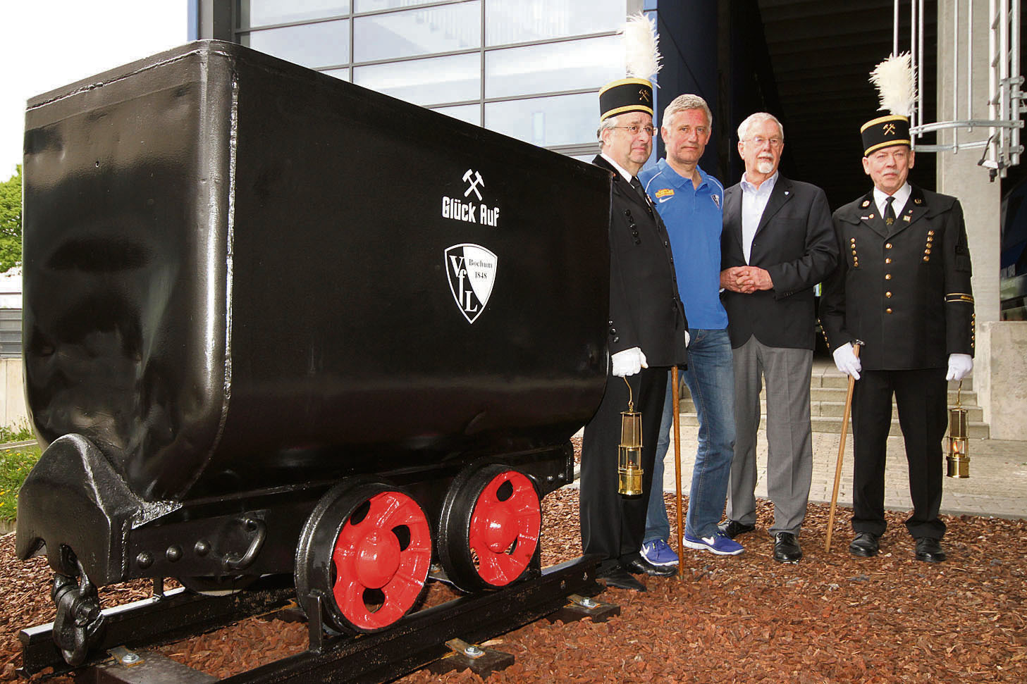 Glückauf, VfL: Als Geschenk der Ruhrkohle AG schmückt eine Kohlenlore mit VfL-Logo jetzt den Stadioneingangsbereich an der Rewirpower-Lounge. Jürgen Niedringhausen (l.) und Werner Netter (r.) überreichten das traditionelle Bergbaugefährt stilecht an den Aufsichtsratsvorsitzenden Ernst-Otto-Stüber (2.v.r.) und Cheftrainer Andreas Bergmann.