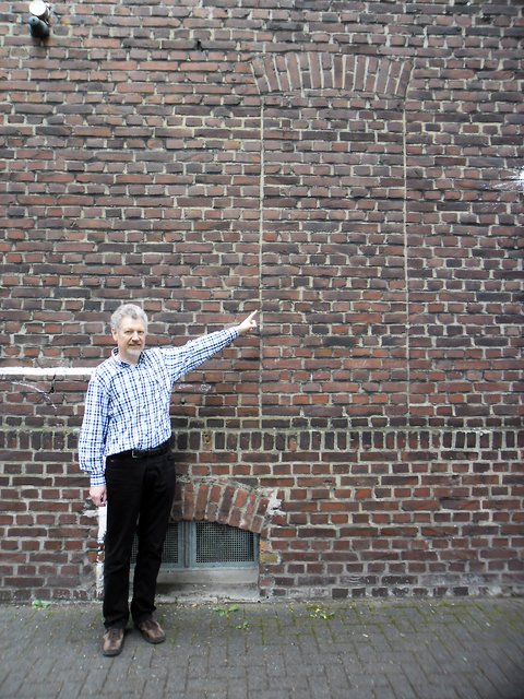 Schulleiter Jürgen Zeglarski zeigt eine Stelle der Fassade, an der eines der Kunstwerke angebracht werden soll.
