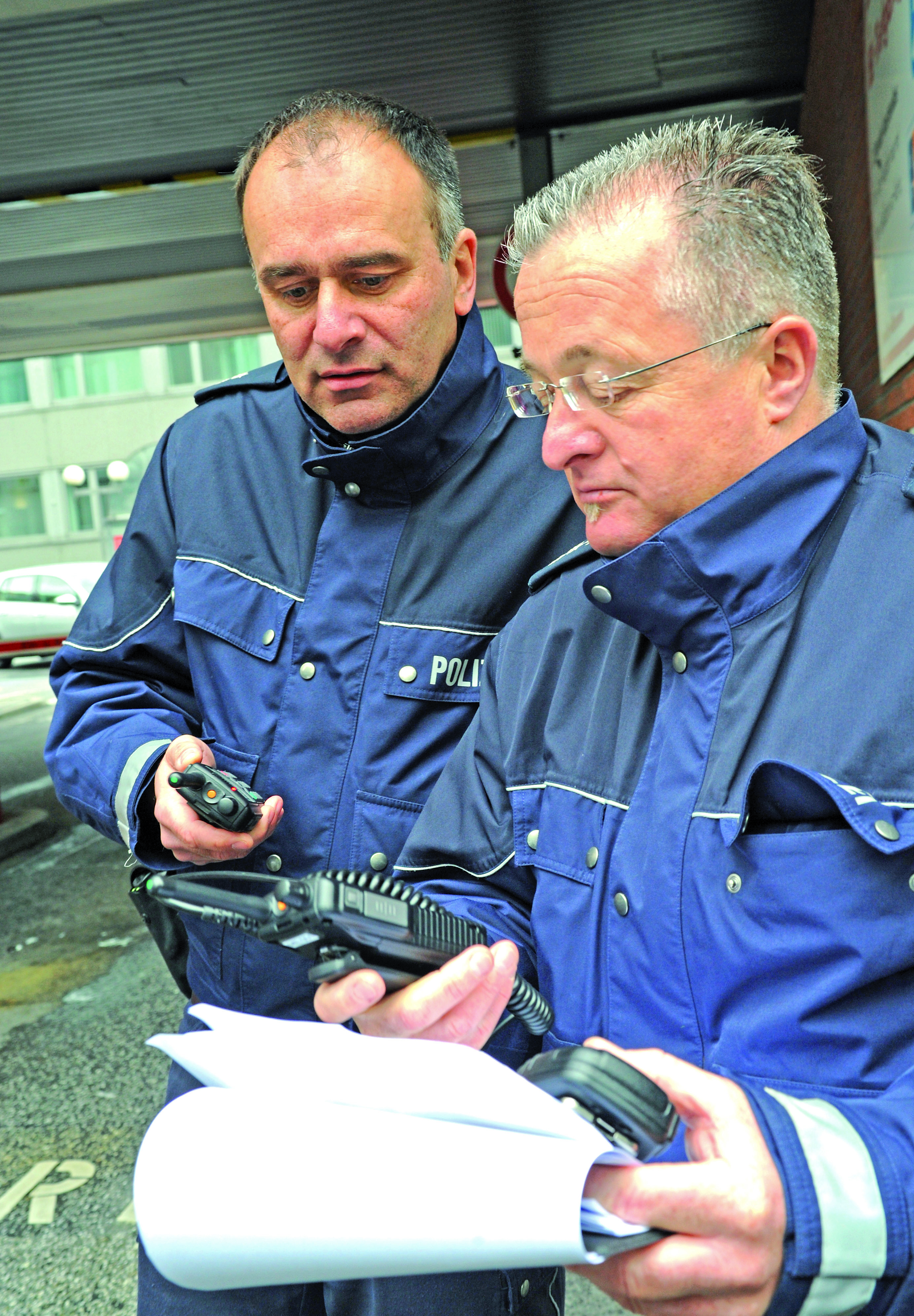 Heiko Giegeling (links) und Dirk Zimmermann vom Polizeisonderdienst stimmen ihre Funkgeräte ab.