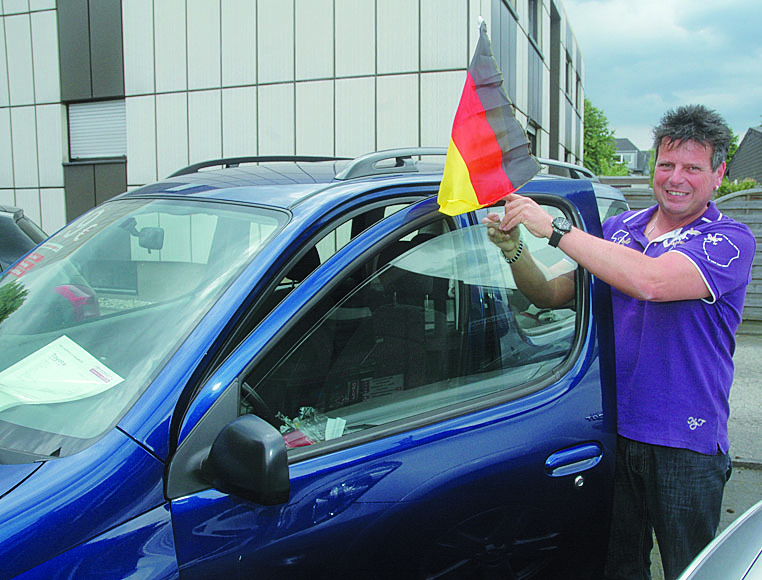 Wenig Verständnis, vor allen Dingen für die „Bekennerschreiben“, hat Autohändler Ralf Wegner. Und so stattete er die Pkw auf seinem Betriebsgelände in Rentfort wieder mit neuen „Deutschland-Fähnchen“ aus. Foto: Rath