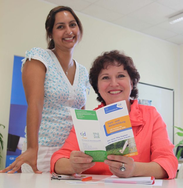 Mitarbeiterin Jennifer Engels (links) und Institutsleiterin Jutta Brillok-Schenke präsentieren das neue Halbjahresprogramm des CJD Institut für Weiterbildung NRW.