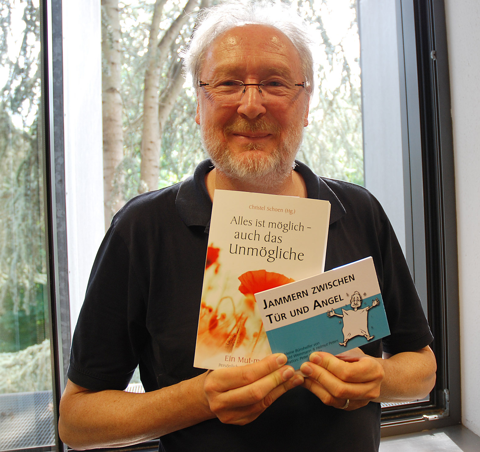 Helmut Peters mit zwei Büchern, an denen er mitgewirkt hat.