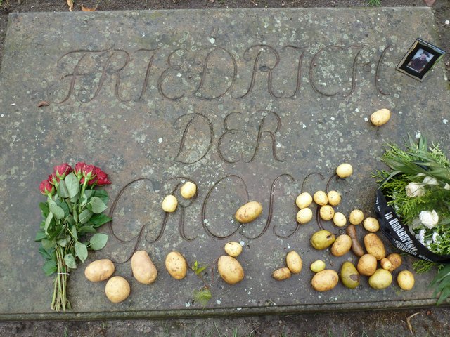 Besucher legen Kartoffeln auf die Grabplatte | Foto: Marita Gerwin