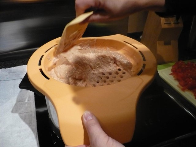 Mit einem Schaber wurde bei uns der Teig durch Löcher gedrückt.