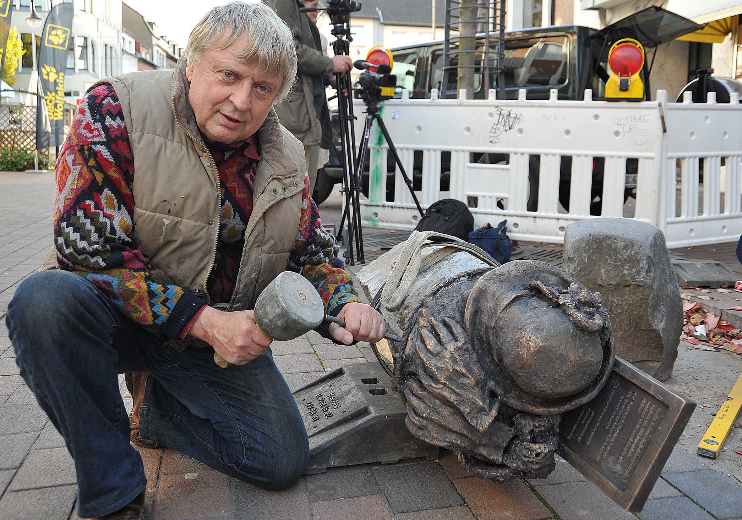 Künstler Alfred Grimm bei der Aufstellung der Mahnsteine in der Dinslakener Flaniermeile an der Duisburgerstraße. Dieser errinnert an das Geschäft der Putzmacherin Elly Eichengrün. Foto: Heinz Kunkel.