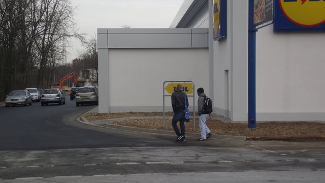 Die Fußgänger laufen in die Fahrbahn der Parkplatzzufahrt hinein ....