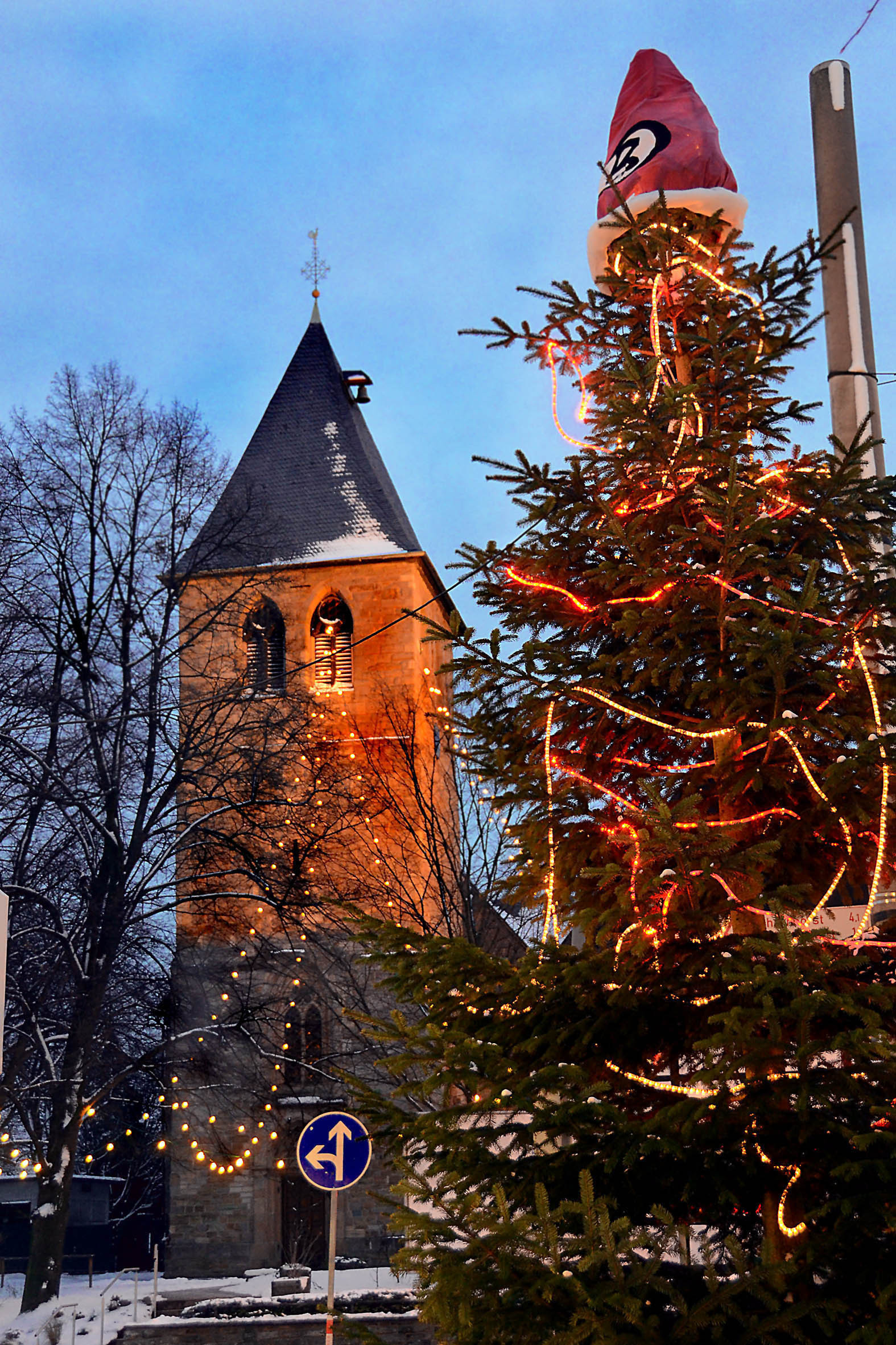 Brackel im weihnachtlichen Lichterglanz. Die vom Gewerbeverein geschmückte Tanne wird von einer Weihnachtsmannmütze gekrönt.