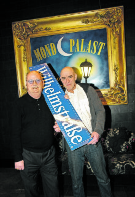 Das Straßenschild „Wilhelmstraße“, das Christian Stratmann (li.) und Thomas Rech umklammern, erinnert an den TV-Dauerbrenner „Lindenstraße“ – aber statt Problem- ist Gagdichte angesagt. Foto: Erler
