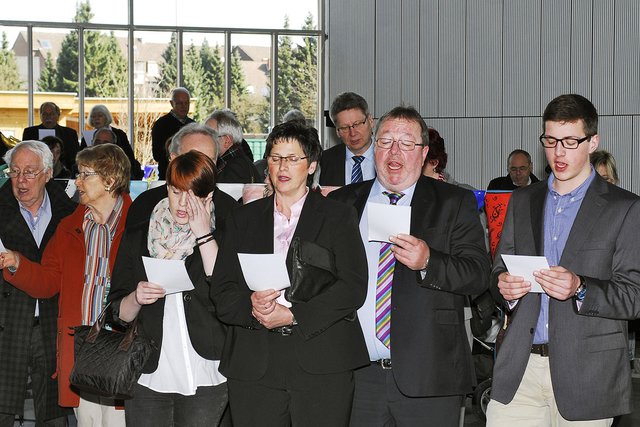 Von Superintendent Dietmar Chudaska musikalisch auf einer Gitarre begleitet sangen die Teilnehmer der Ausstellungseröffnung gemeinsam das Lied „Aufstehn, aufeinander zugehn“.
