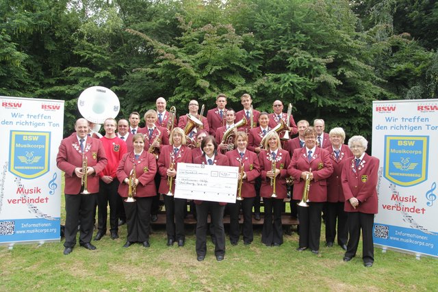 Das Musikcorps Hohenbudberg präsentiert den symbolischen Scheck für die Flutopfer