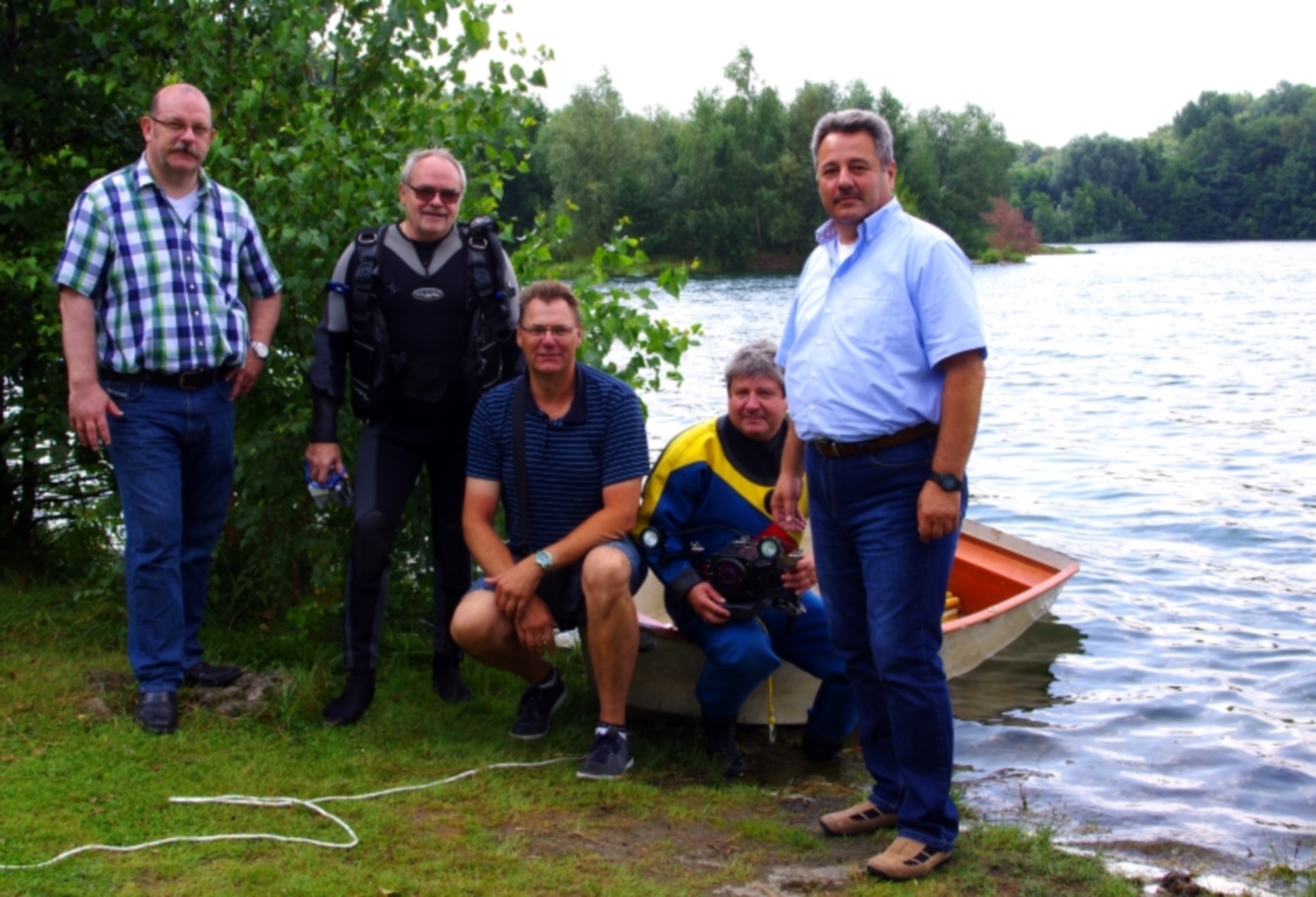Bei einem aktuellen Termin vor Ort informierte Peter Hoppe, Vorsitzender der Duisburger Taucher (2.v.l.), und Erik Hesse (2.v.r.) den Vorsitzenden des ortsansässigen Angelvereins Uwe Schrott (ASV Rheinpreussen Waldsee e.V., sitzend Mitte) und die beiden Ratsherren Bruno Sagurna (SPD-Duisburg, rechts) und Claus Peter Küster (FBG-Moers, links) über die Ergebnisse der ersten beiden Tauchgänge
