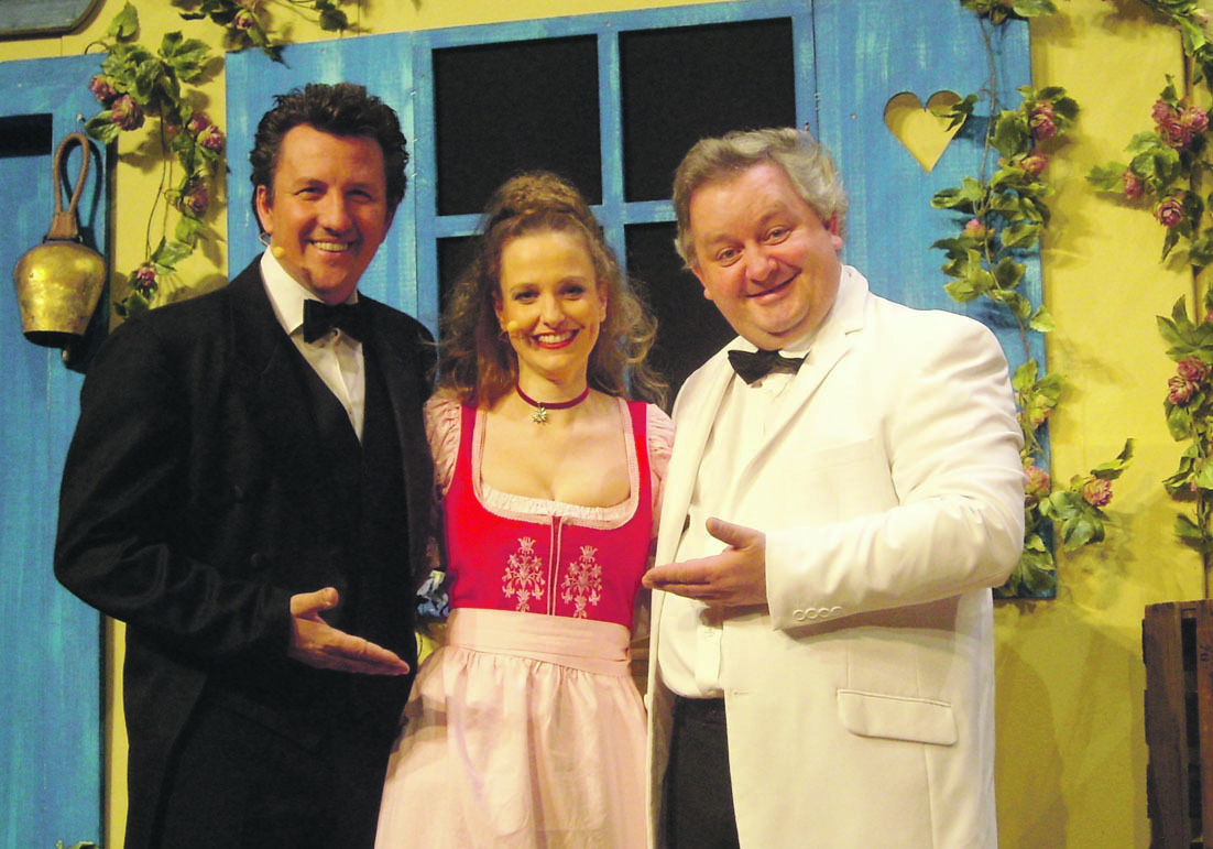Peter Grimberg und Horst Freckmann umrahmen ein fesches "Rössl-Zimmermädchen". Foto: Produktion Servus Peter.
