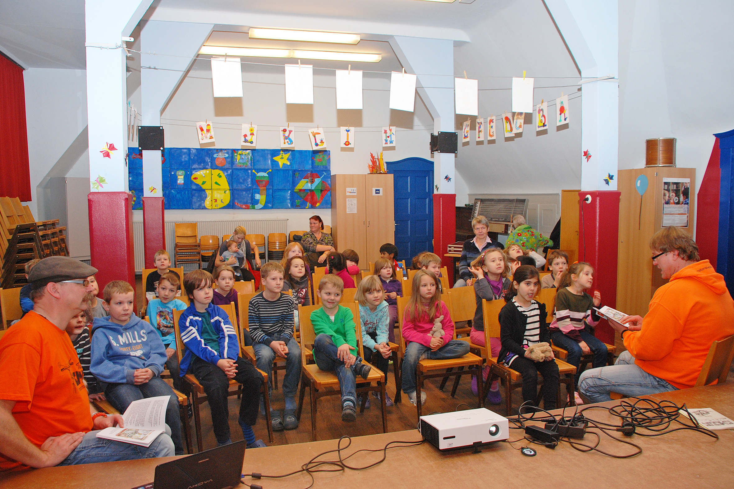 Carsten Jankowski (r.) las der Klasse 1a der Wilhelmschule aus seinem Buch „Das kleine Motorrad Emelie“ vor, für das Berthold B. Knopp (l.) die Illustrationen gemacht hat. Foto: Vera Demuth