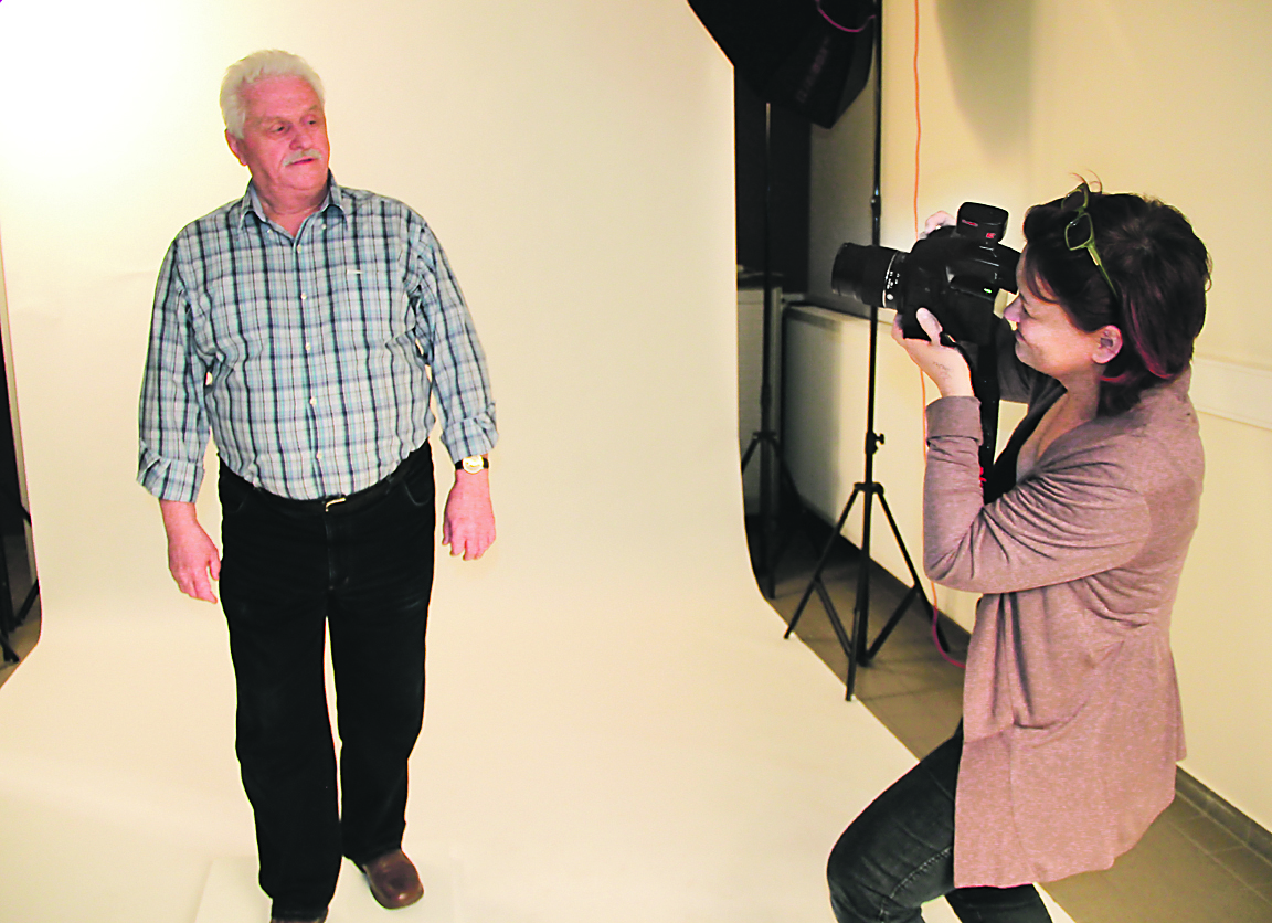 Astrid Heups bei der Arbeit im provisorischen Foto-Studio mit Walzwerker Herbert Halfter (69). Die Solinger Fotografin hatte die Grundidee zu der Aktion. Foto: Römer