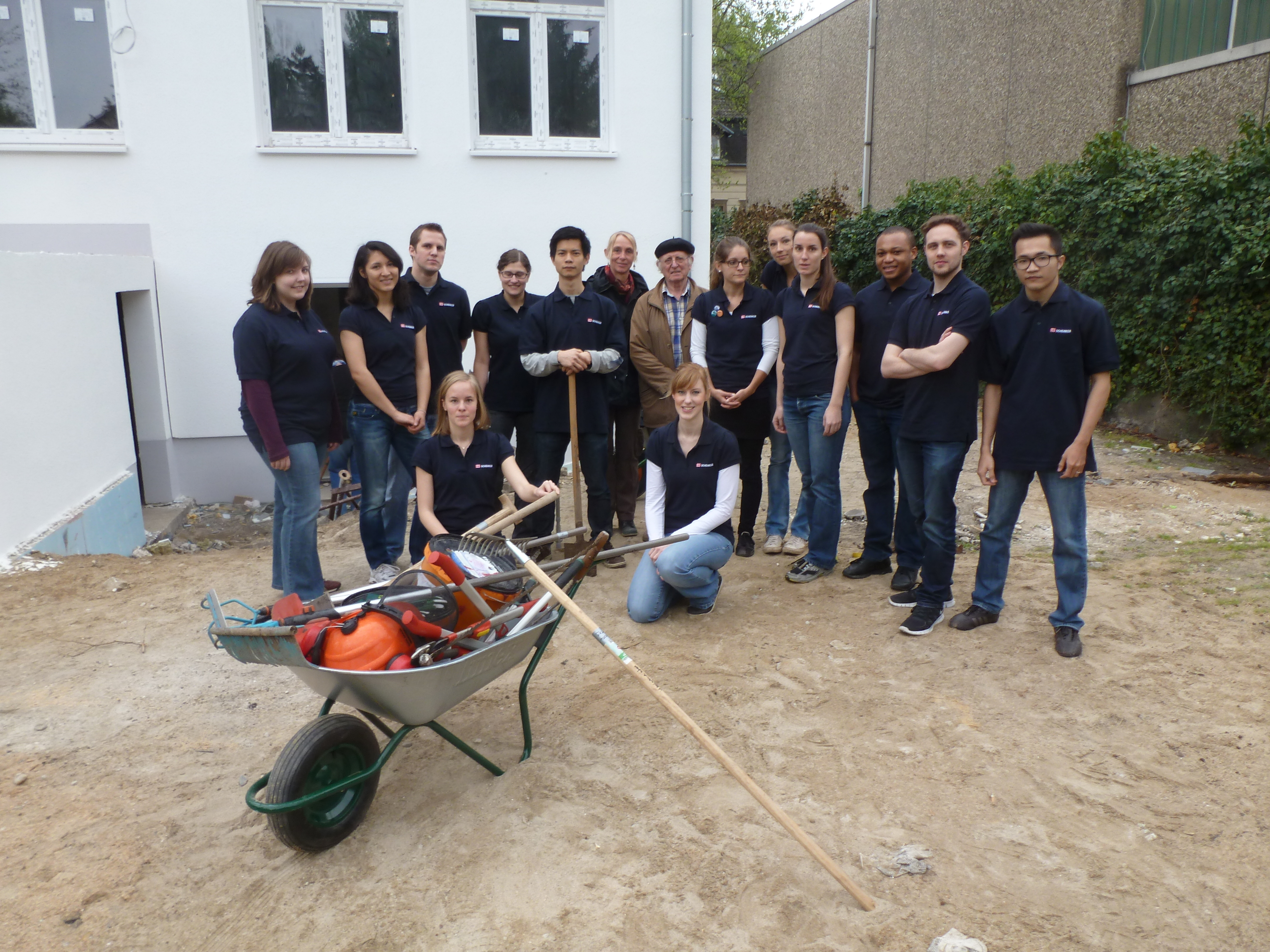 Umringt von 14 kleinen und großen Helfern: Die Trainees der DB Schenker AG mit Philipp Neßling (mi.), Vorstandsvorsitzender des Integrationsmodells.
