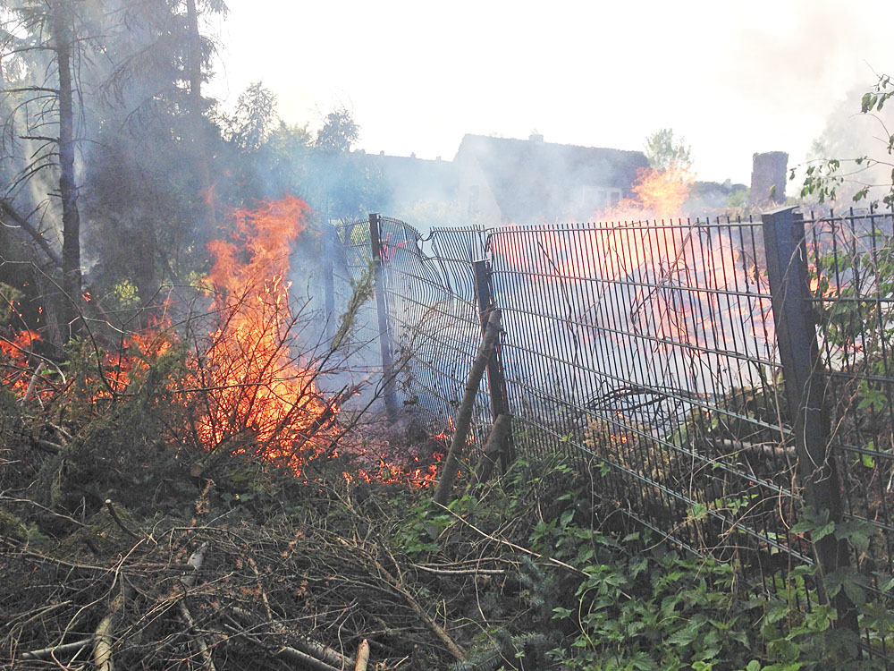 Außer Kontrolle: Ein Osterfeuer auf einem Privatgrundstück am Samstag in Herten. Die Feuerwehr musste anrücken, um einen Großbrand in der Siedlung zu verhindern.